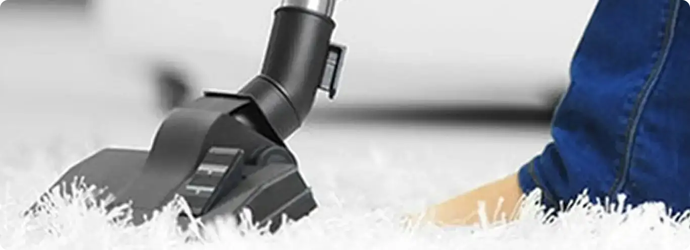 Close-up of a professional vacuuming a white carpet in Clovis.